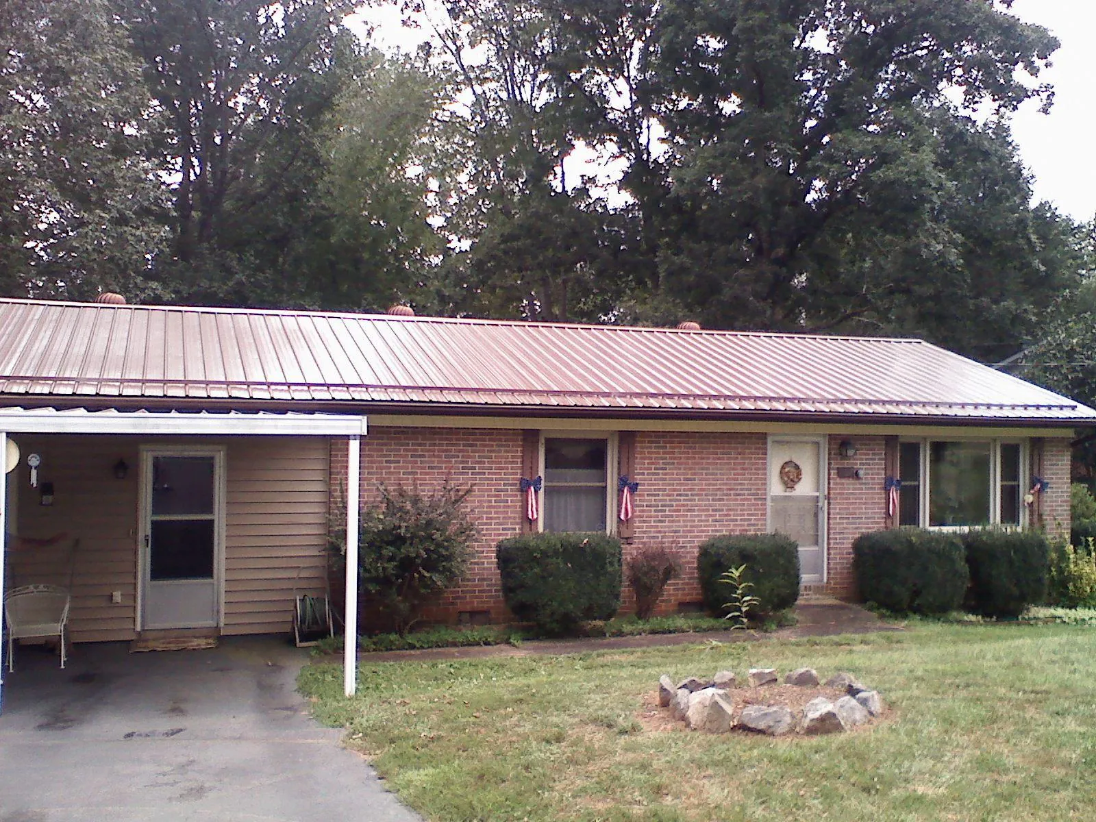 Bronze metal roof and carport on a brick ranch home — Roof Repair work by our crew in Saint Rose